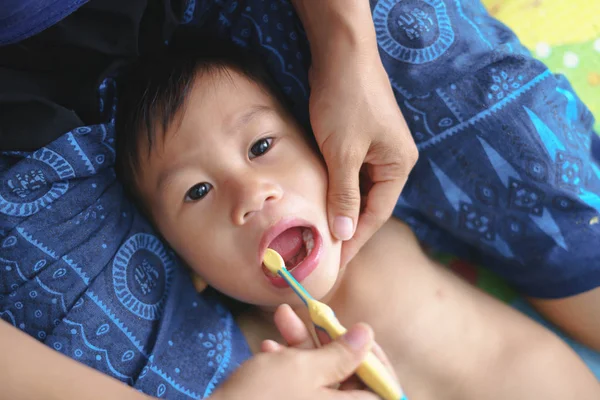 Asiática madre ayudando a su niño cepillarse los dientes para el cuidado dental — Foto de Stock