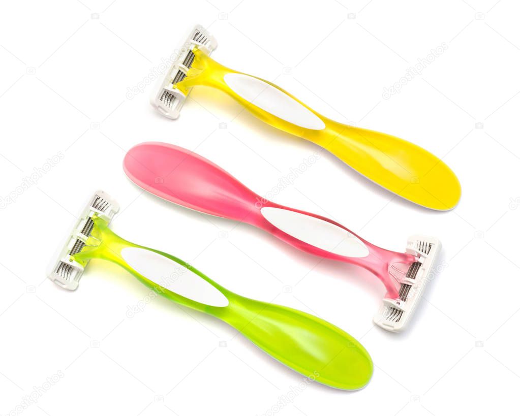 Set of three multi-colored women's shaving razors isolated on white background. Pink, green and yellow. Flat lay, top view