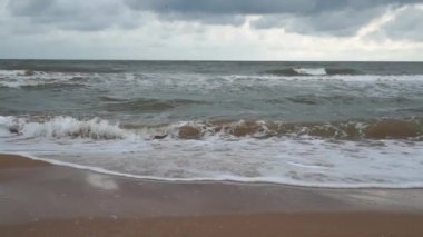 Denizde fırtına. Fırtınalı havada Azov Denizi kıyısında. Dalgalar, rüzgar ve deniz püskürtüsü. Rusya