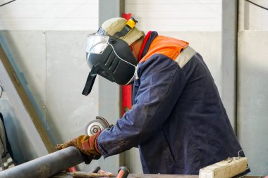 Nitelikli bir kaynakçı, boru hattının kıç kaynaklarını söküyor. 