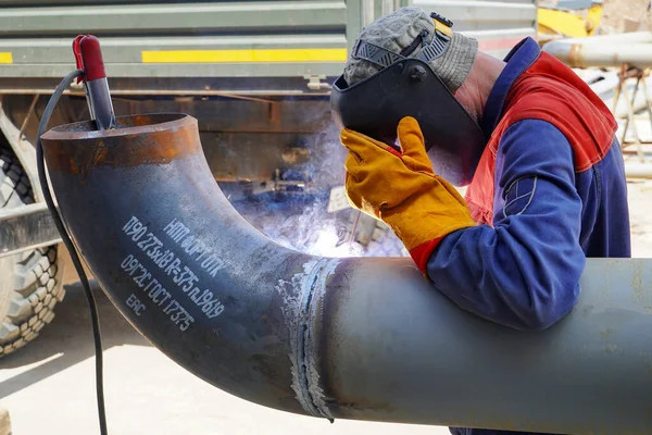 Profesyonel bir kaynakçı, elektrot kullanarak manuel kaynak yapar ve Rusya 'daki bir petrol rafinerisi için DN 250' lik bir teknolojik boru hattı kaynağı alır.                 