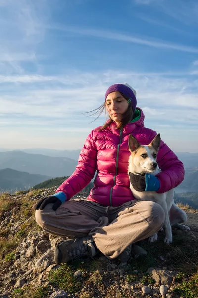 Menina com cão relaxante em um pico Fotos De Bancos De Imagens Sem Royalties