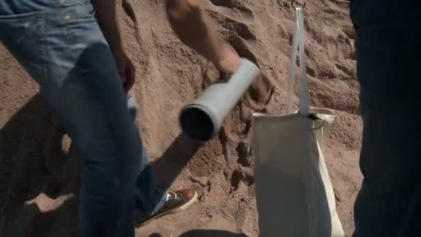 Preparare il palloncino per il volo. Gli uomini riempiono borsa di sabbia — Video Stock