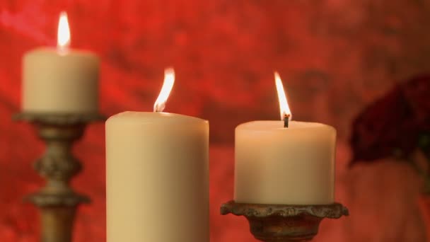 Fiamma tremolante di candele su sfondo rosso — Video Stock