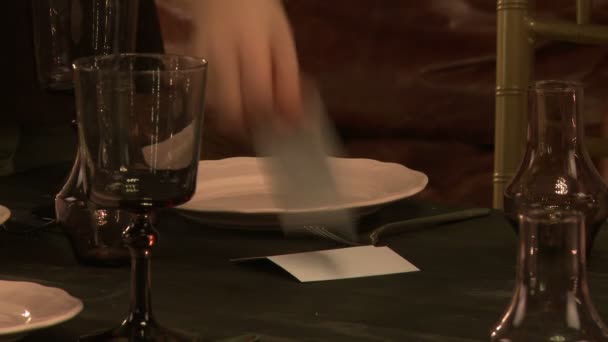 Restaurant worker lays out name cards in plate — Stock Video