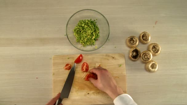 Laga mat. Ovanifrån av kocken skär fint tomat — Stockvideo