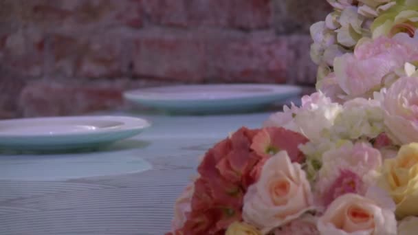 Buquê de flores na mesa contra a parede de tijolo — Vídeo de Stock