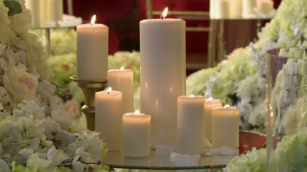 Зажженные свечи различной высоты и цветов — стоковое видео