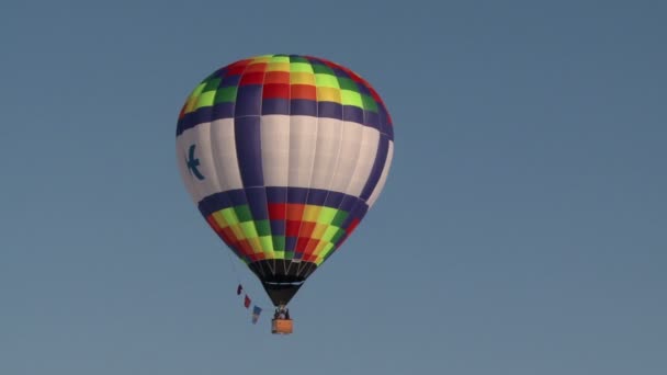 Balão de ar quente colorido voando no céu claro — Vídeo de Stock