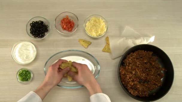 Вид от первого лица на шеф-повара измельчает начос в блюде — стоковое видео