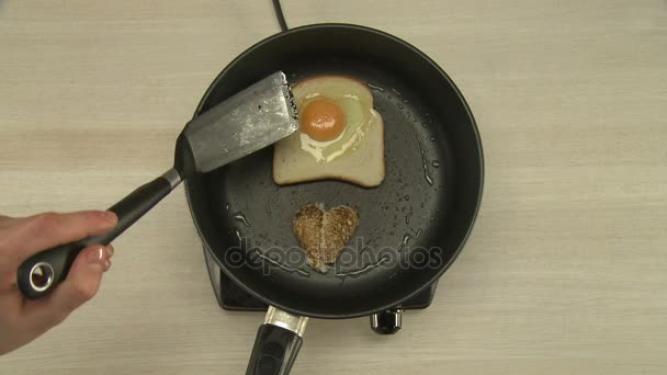 Приготовление завтрака с яичницей и тостами — стоковое видео