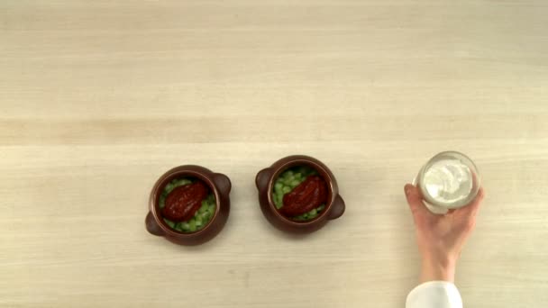 Cuisinière mettant du ketchup dans des pots avec des légumes — Video