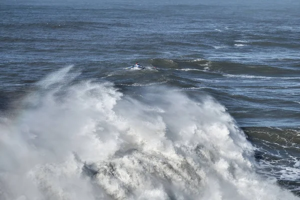 Tým surfování v oceánu, velké vlny, Nazare, Portugalsku — Stock fotografie