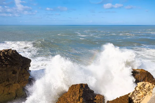 Grote oceaan golven op de rotsen van Nazare. Stockfoto