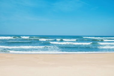 Sandy beach ve dalgalı dalgalar. Beyaz kum, mavi gökyüzü ve kristal denizin tropikal Beach