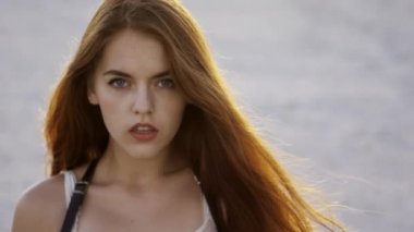 Ağır çekimde gün batımında iri gözlü düşünceli kız Close-Up