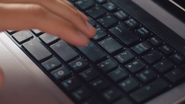 Close-up de um jovem imprensa entrar em um teclado laptop — Vídeo de Stock