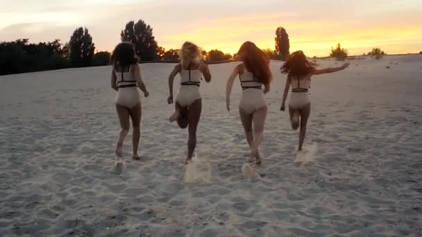 Ön plana genç kızlar çalıştırmak grup yavaş gün batımında — Stok video