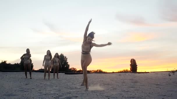 Девушки бегают и прыгают на закате в замедленной съемке — стоковое видео