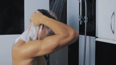Yıkama saç ve kullanılması şampuan duş, yavaş hareket altında genç adam
