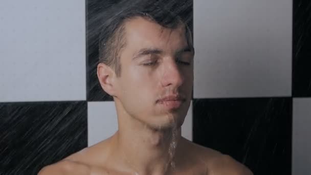 Close-up van portret van man staat onder douche, slow-motion — Stockvideo