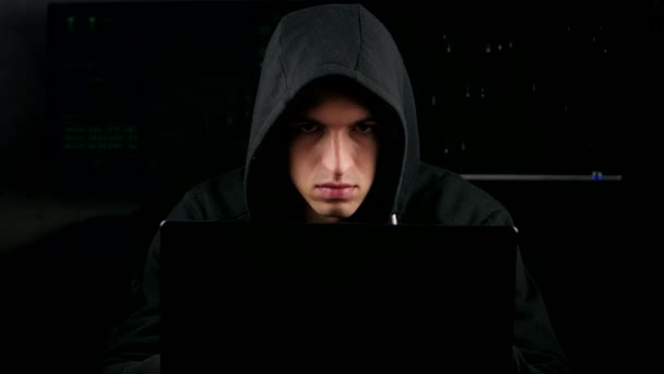暗いオフィス ルームにあるコンピューターにフード付き作業でハッカー — ストック動画