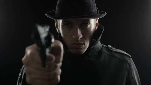 Porträt eines Gangsters mit Hut und schwarzem Umhang bedroht Waffe