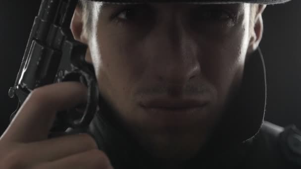 Nahaufnahme Porträt eines Gangsters mit Hut und schwarzem Mantel mit Waffe
