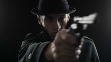 gangster bir şapka ve siyah pelerin. Kamera silah hedefleyen bir mafya