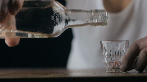 Nahaufnahme eines Mannes, der Wodka in einem dunklen Raum in Zeitlupe trinkt — Stockvideo