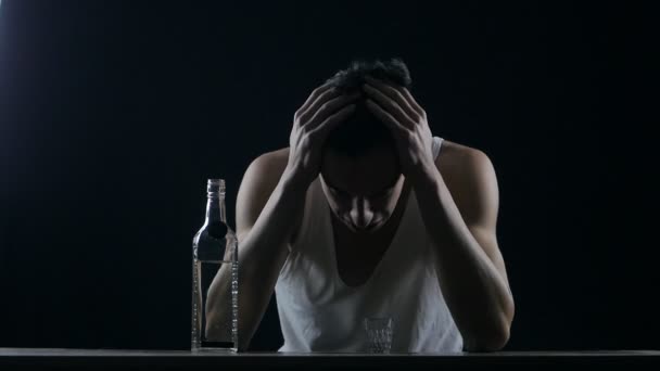 Un hombre deprimido llorando con una botella de vodka. hombre desesperado — Vídeos de Stock