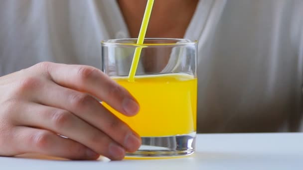 Hombre bebiendo refresco de naranja con una pajita — Vídeo de stock