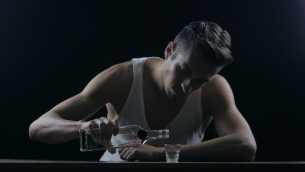 Depressieve man die het drinken van wodka in een donkere kamer — Stockvideo