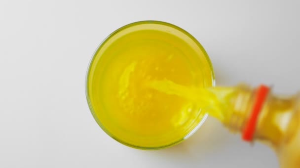 Pouring orange juice soda in glass in slow motion — Stock Video