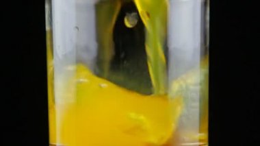 Ağır çekimde bardakta portakal suyu tozu dökme