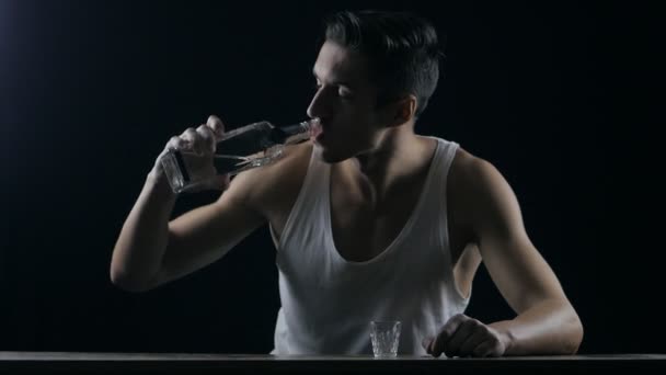 Depressed man drinking vodka in a dark room — Stock Video