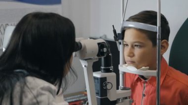 Çocuk renk görme bir göz doktoruna resepsiyonda denetler.