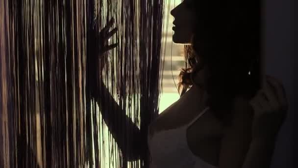 配置文件在门口透过窗帘的导电手性感的女孩 — 图库视频影像
