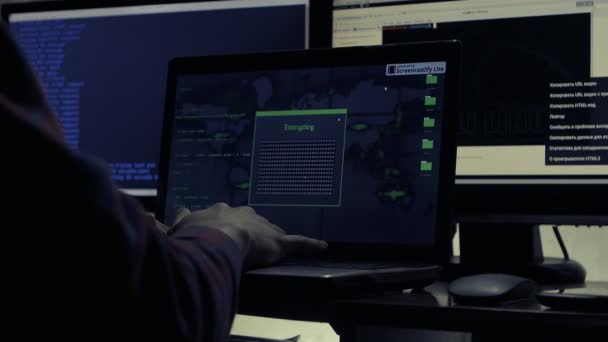 Hacker arbeiten an einem Computer in einem dunklen Büroraum — Stockvideo