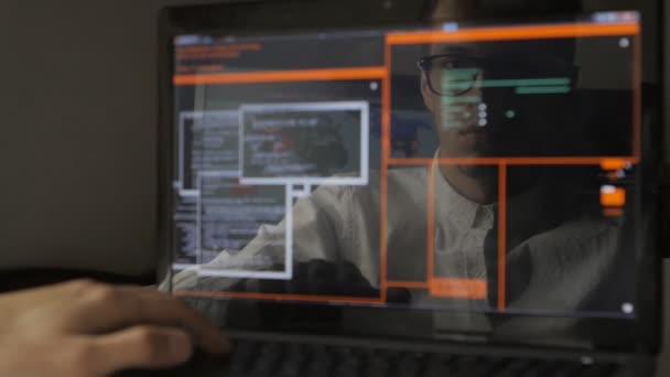 Man som arbetar på en bärbar dator i reflektion av bildskärmen — Stockvideo
