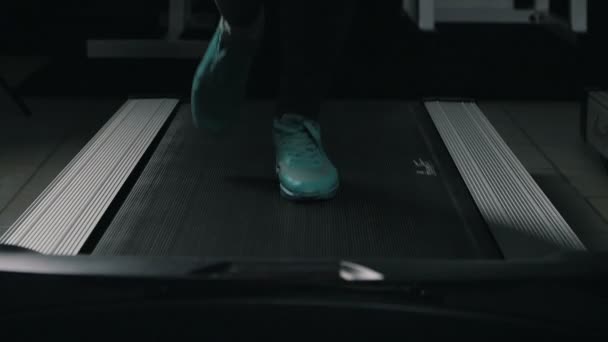 Närbild av kvinnans fötter körs på ett löpband i sport gym i slowmotion — Stockvideo