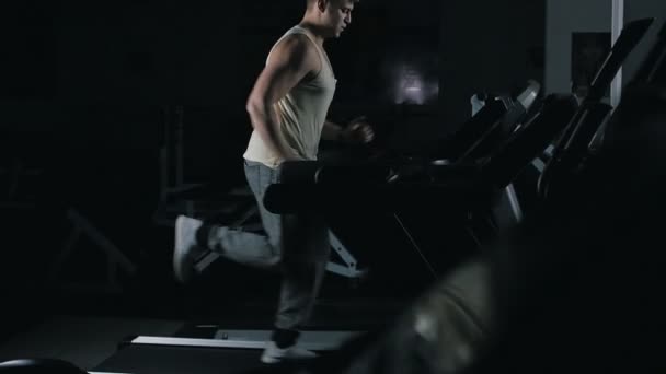 Man kör på ett löpband i sport gym i slowmotion — Stockvideo