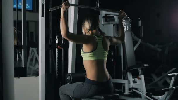 Атлетическая девчонка в тренажерном зале снимает "Широкий захват" за шеей — стоковое видео