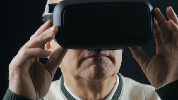 Nahaufnahme eines älteren Mannes, der Erfahrungen im Umgang mit VR-Headset im dunklen Raum sammelt — Stockvideo