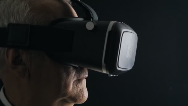 Close-up shot van senior man krijgt ervaring in het gebruik van Vr-headset in donkere kamer — Stockvideo