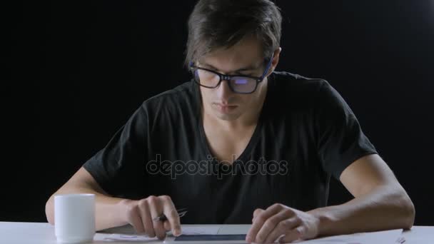 Joven hombre de negocios revisando el mercado de valores en su tableta — Vídeo de stock