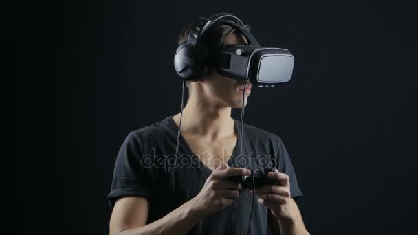 Rzeczywistość wirtualna gra. Człowiek z przyjemnością wykorzystuje wyświetlacz głowy zamontowane w ciemnym pokoju — Wideo stockowe