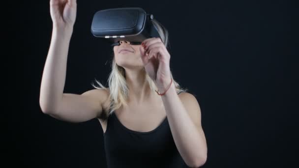 Gros plan sur une femme qui acquiert de l'expérience dans l'utilisation d'un casque VR dans une pièce sombre — Video