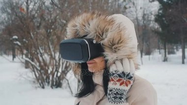 genç kadın Vr-kulaklık açık kış Park'taki kullanarak deneyim elde