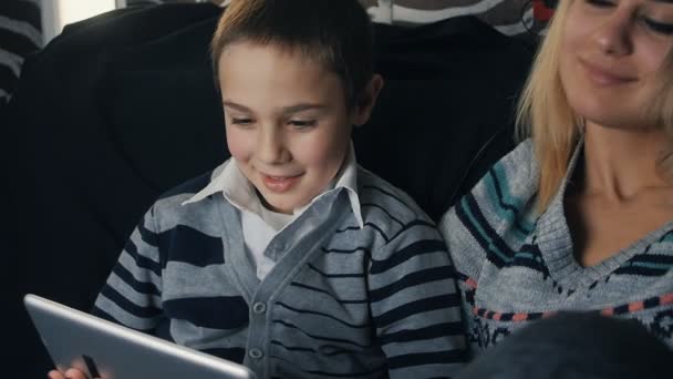 幸せな家族の母親と子供は、タブレット pc を使用して。スローモーション — ストック動画